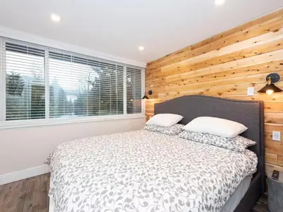 a bedroom with a bed with a wooden wall at Whistler Village Center - Newly Renovated Condo in Whistler