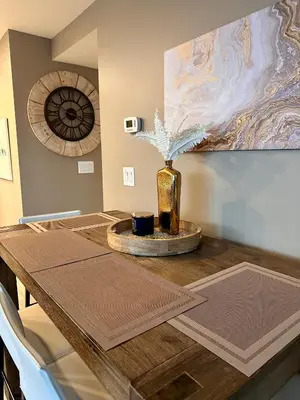 a dining room table with a vase on top of it at Century Park Condo Oasis in Edmonton