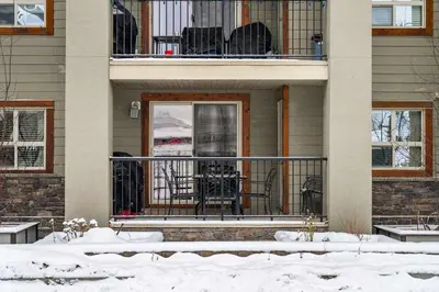 a house with a balcony with a table and chairs at Aspen Retreat in Invermere