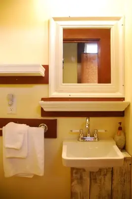 a bathroom with a sink and a mirror and towels at Victoria Falls House Inn in Nelson