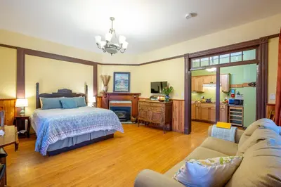 a bedroom with a bed and a living room at Victoria Falls House Inn in Nelson