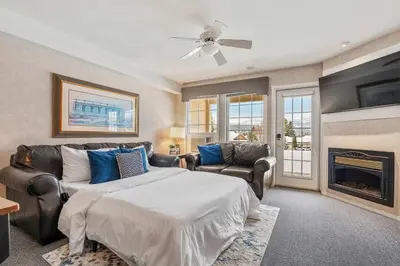a bedroom with a bed and a couch and a fireplace at Vista in Fairmont Hot Springs