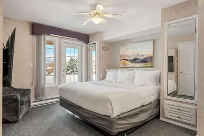 a bedroom with a large bed with a ceiling fan at Vista in Fairmont Hot Springs