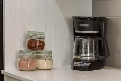 a coffee maker and jars on a shelf in a refrigerator at Free Parking, Close to Downtown, Pet Friendly in Calgary