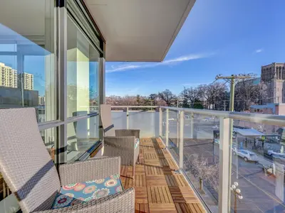 a balcony with chairs and a view of a city at Escher Escape - Art-filled retreat with work desk by Victoria Prime! in Victoria