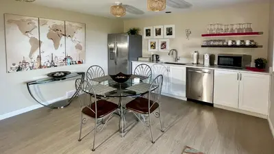 a kitchen with a table and a refrigerator at Lake and the City Bed and Breakfast in West Kelowna