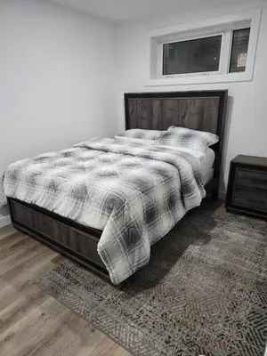 a bedroom with a bed with a blanket and a rug at Staycation3179 in Edmonton