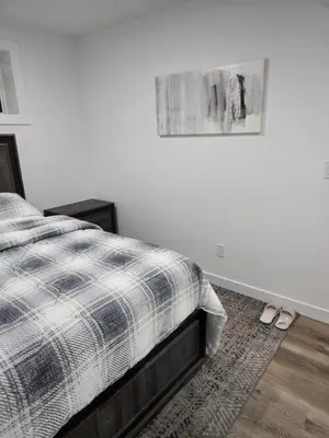 a bedroom with a bed and a picture on the wall at Staycation3179 in Edmonton