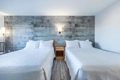 two beds sitting next to each other in a room at Blue Horse Motel in Beiseker