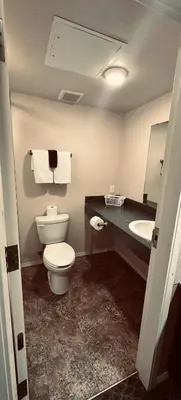 a bathroom with a toilet and a sink at Voyageur Motel in Rocky Mountain House