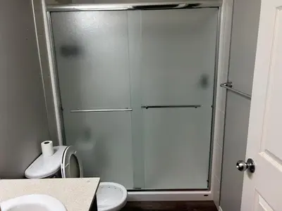 a glass shower in a bathroom with a toilet at Bedroom SW Edmonton HWY 2 near YEG in Edmonton