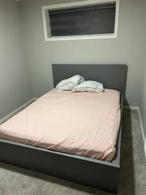 a bed with pink sheets and two pillows on it at Bedroom SW Edmonton HWY 2 near YEG in Edmonton