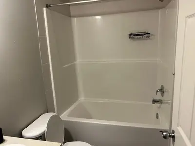 a white bathroom with a tub and a toilet at Bedroom SW Edmonton HWY 2 near YEG in Edmonton
