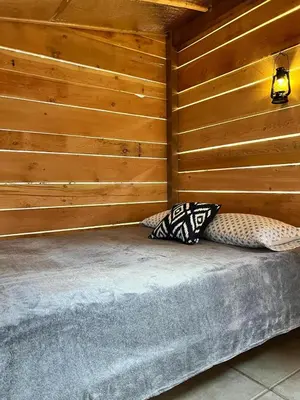 two pillows sitting on a bed in a room at Butterfly Cottage - Glamping in Oliver