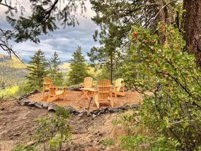 a group of chairs and a table in the woods at Butterfly Cottage - Glamping in Oliver