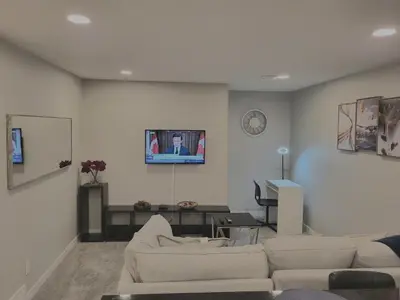 a living room with a couch and a tv on a wall at Home away from Home in Calgary