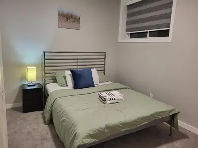 a bedroom with a bed with a pillow on it at Home away from Home in Calgary