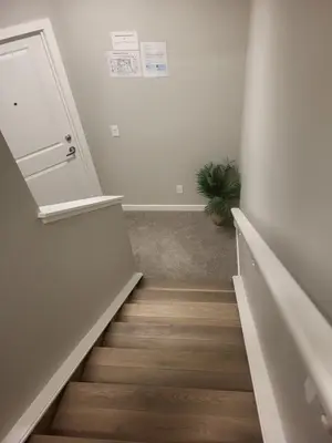 a hallway with stairs with a door and a plant at Home away from Home in Calgary