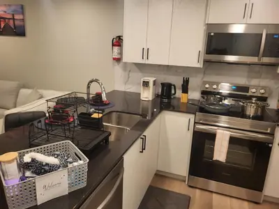 a kitchen with a sink and a stove top oven at Home away from Home in Calgary