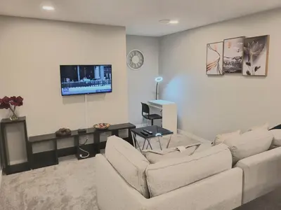 a living room with a couch and a tv on a wall at Home away from Home in Calgary