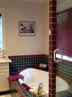 a bathroom with a bath tub and a sink at Wisteria Honeymoon Cottage in Sooke