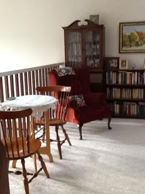 a living room with a couch and a table and chairs at Wisteria Honeymoon Cottage in Sooke