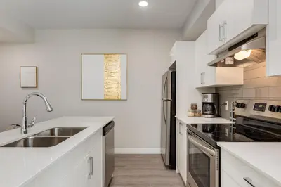 a kitchen with white counters and a sink at Inner City Apartment, Pet Friendly, Free Underground Parking in Calgary