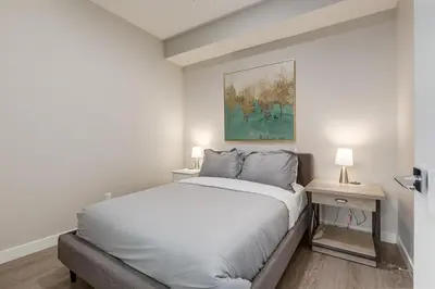 a bedroom with a bed and a painting on the wall at Inner City Apartment, Pet Friendly, Free Underground Parking in Calgary