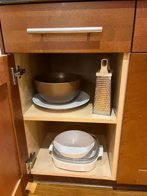 a cabinet with a bowl and plates in it at Place near the Coquitlam River Park in Coquitlam