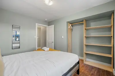 a bedroom with a large white bed and shelves at Home Alone Retreat in Calgary