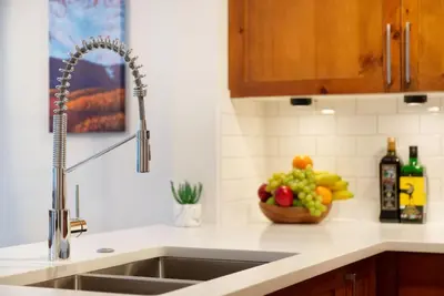 a kitchen counter with a sink and a bowl of fruit at Northstar Whistler Village Resort in Whistler