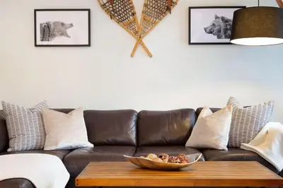 a brown leather couch with a bowl of food on a coffee table at Northstar Whistler Village Resort in Whistler