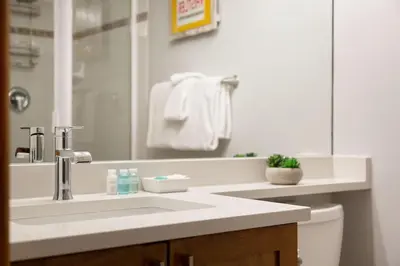 a bathroom with a sink and a toilet and a mirror at Northstar Whistler Village Resort in Whistler