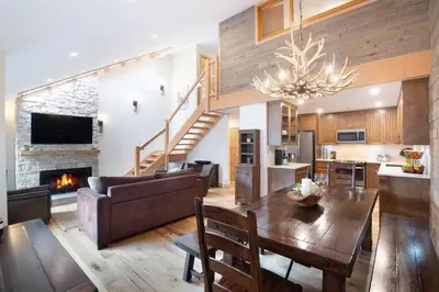 a living room with a couch and a table and a fireplace at Large Village loft with Private Hot Tub and Private Sauna in Whistler