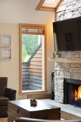 a living room with a fireplace and a television at Large Village loft with Private Hot Tub and Private Sauna in Whistler