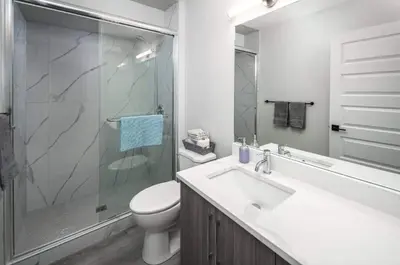 a bathroom with a toilet and a sink and a shower at Near Downtown, Large 3BR! FREE Banff Pass, Netflix, Parking! in Calgary