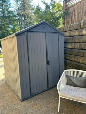a black shed with a chair and a bench at Garden Suite in Colwood in Victoria