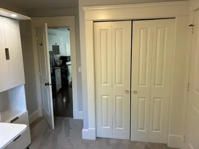 a kitchen with white closet doors in a room at Garden Suite in Colwood in Victoria