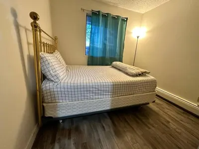 a bedroom with a bed and a lamp in it at Victoria Trail Apartments in Edmonton