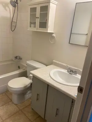 a bathroom with a toilet and a sink and a mirror at Victoria Trail Apartments in Edmonton
