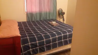a bedroom with a bed with a blue plaid at Victoria Trail Apartments in Edmonton