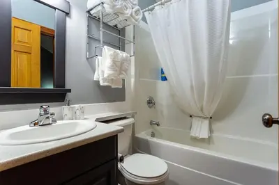 a bathroom with a sink and a toilet and a shower at BigWhite Ski In-Out Chalet w Priv HotTub & Garage in Big White
