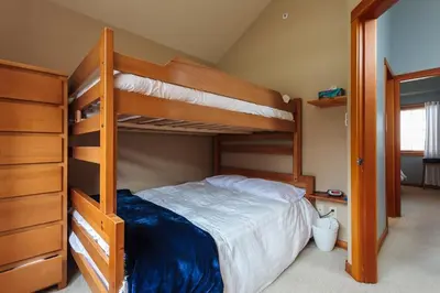 a bedroom with two bunk beds in a room at BigWhite Ski In-Out Chalet w Priv HotTub & Garage in Big White