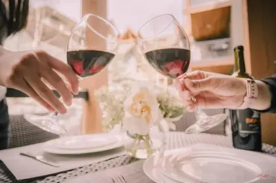 two people holding glasses of red wine on a table at C111 Canmore World Class Solara Resort - Hot tub, Pool, Gym, AirCon, Free Parking & Netflix in Canmore