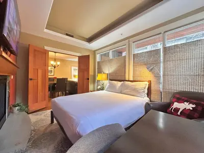 a bedroom with a bed and a couch and a tv at C111 Canmore World Class Solara Resort - Hot tub, Pool, Gym, AirCon, Free Parking & Netflix in Canmore