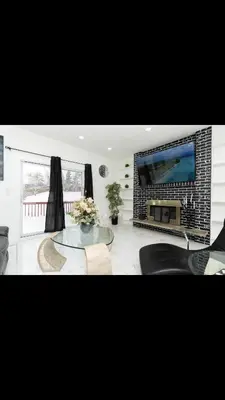 a living room with a fireplace and a large tv at Modern and luxury 3500 sq feet house jetted tub over 10000 sq feet lot in Edmonton