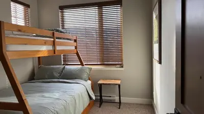 a bedroom with a bunk bed and a window at Powder Heights #25 home in Sun Peaks