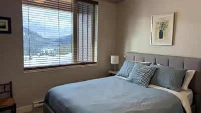 a bedroom with a bed with a large window at Powder Heights #25 home in Sun Peaks