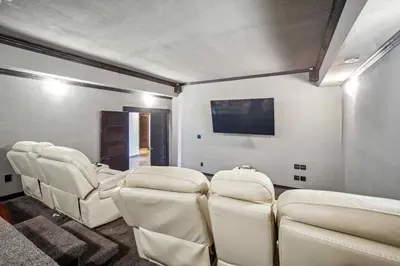 a waiting room with white chairs and a flat screen tv at Luxurious Modern 11-Bed Home Private 136 Acres in Spruce Grove