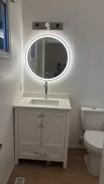 a white bathroom with a sink and a mirror at Kevin Calgary Beddington Home in Calgary